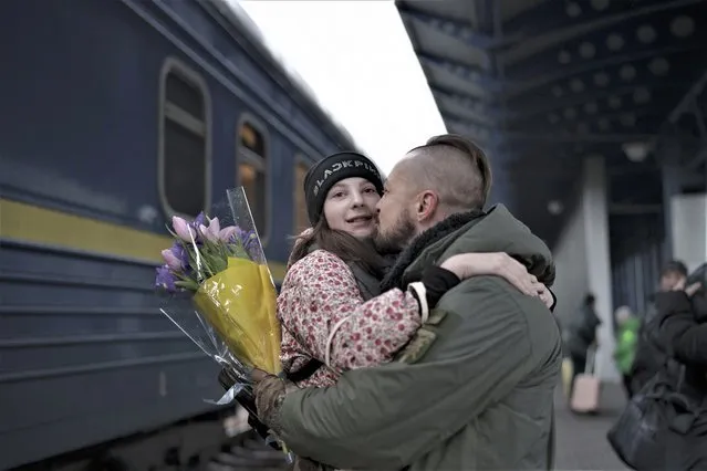 Ukrainian soldier Vasyl Khomko, 42, hugs his daughter Yana as she arrives at the train station in Kyiv, Ukraine, Saturday, December 31, 2022. Khomko's wife and daughter have been living in Slovakia due to the war but returned to Kyiv to spend New Year's Eve together. (Photo by Roman Hrytsyna/AP Photo)