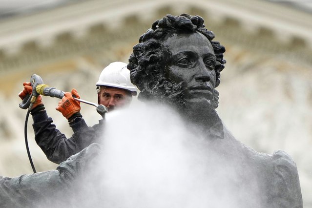 A worker cleans a statue of famous Russian poet Aleksander Pushkin in St. Petersburg, Russia, Monday, May 26, 2025. (Photo by Dmitri Lovetsky/AP Photo)