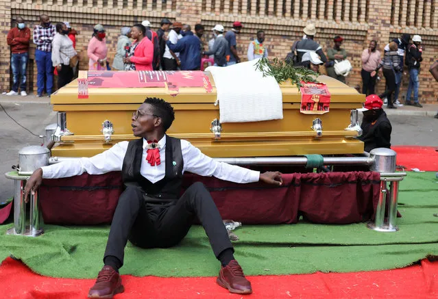 A striking funeral worker takes a break near a casket placed at a parking lot as they protest over changes to a host of procedures and regulations, during the coronavirus disease (COVID-19) outbreak outside the department of home affairs in Soweto, South Africa, September 16, 2020. (Photo by Siphiwe Sibeko/Reuters)