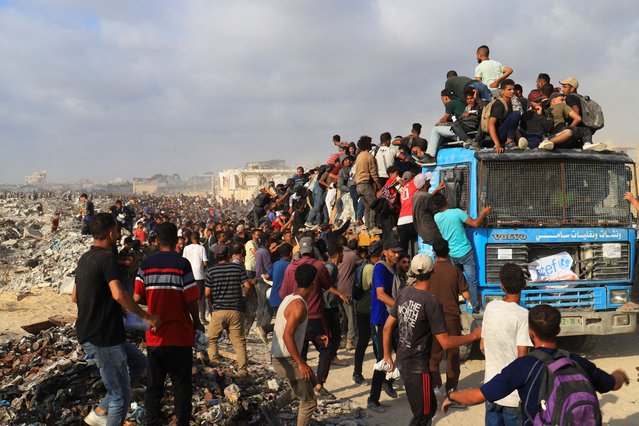 Palestinians climb a vehicle as they gather to receive aid supplies in Beit Lahia, in the northern Gaza Strip on June 23, 2025. (Photo by Ebrahim Hajjaj/Reuters)