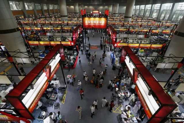 Buyers walk inside a venue for large machinery and equipment at the China Import and Export Fair, also known as Canton Fair, in the southern Chinese city of Guangzhou October 15, 2015. (Photo by Bobby Yip/Reuters)