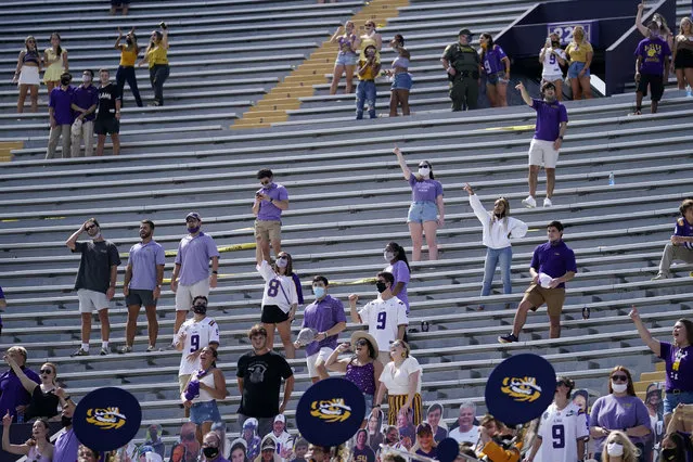 A limited number of fans in the student section, seated according to COVID-19 restrictions requiring social distancing and masks, watch in the first half an NCAA college football game between LSU and Mississippi State in Baton Rouge, La., Saturday, September 26, 2020. Mississippi State won 44-34. (Photo by Gerald Herbert/AP Photo)