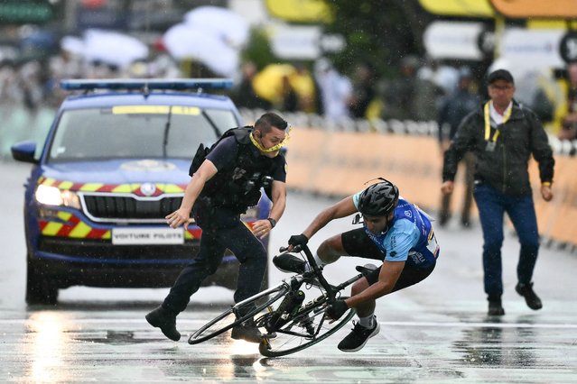 A French Republican Security Corps (CRS – Compagnies Republicaines de Securite) officer tackles an individual attempting to cycle across the finish line minutes before the final sprint of the 112th edition of the Tour de France cycling race, 160.4 km between Bollene and Valence, southern France, on July 23, 2025. (Photo by Marco Bertorello/AFP Photo)