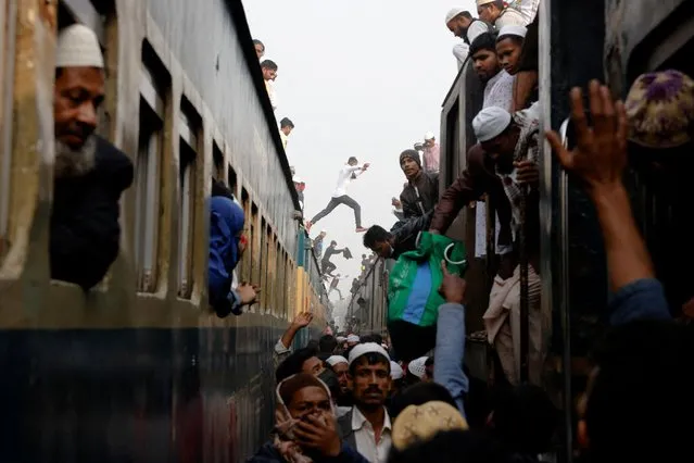 People jump between trains as Muslim devotees travel on the rooftops of overcrowded trains to return home, after attending the final prayer of Bishwa Ijtema, which is considered the world’s second-largest Muslim gathering after Haj, in Tongi, outskirts of Dhaka, Bangladesh on January 15, 2023. (Photo by Mohammad Ponir Hossain/Reuters)