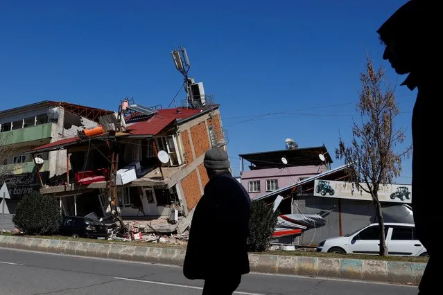 People walk near a damaged building in the aftermath of a deadly earthquake, in Kahramanmaras, Turkey on February 9, 2023. (Photo by Suhaib Salem/Reuters)