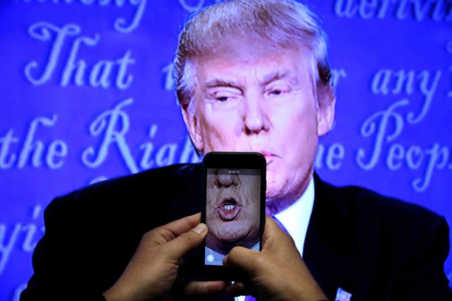 A journalist records a video from screen as Republican U.S. presidential nominee Donald Trump speaks during the first presidential debate with U.S. Democratic presidential candidate Hillary Clinton at Hofstra University in Hempstead, New York, U.S. on September 26, 2016. (Photo by Carlos Barria/Reuters)