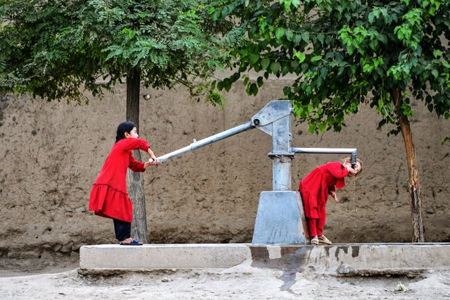 An Afghan girl drinks water from a hand pump at Fayzabad district in Badakhshan province on August 5, 2025. (Photo by Omer Abrar/AFP Photo)