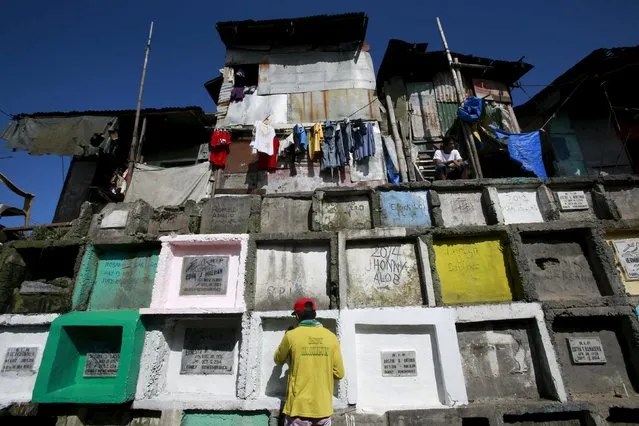 A man repaints the tomb of his departed relative buried in an "apartment-style" grave inside a cemetery in Navotas city, north of Manila October 31, 2015. (Photo by Romeo Ranoco/Reuters)