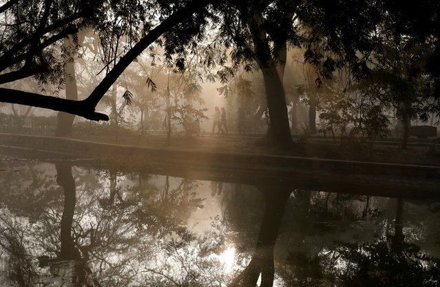People walk by a lake at a public park on a foggy winter morning in New Delhi, India January 19, 2018. (Photo by Saumya Khandelwal/Reuters)