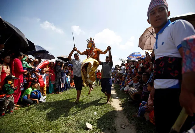 A medium dressed as a deity jumps during a trance while celebrating Shikali festival at Khokana village in Lalitpur, Nepal October 7, 2016. (Photo by Navesh Chitrakar/Reuters)
