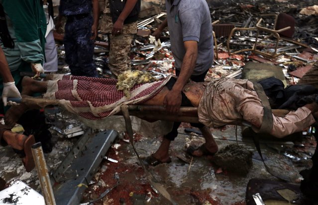 Yemenis carry the body of a victim of Saudi-led airstrikes that hit a funeral ceremony in Sana'a, Yemen, 08 October 2016. According to reports, at least 82 Yemenis were killed and more than 534 injured when Saudi-led airstrikes hit a funeral hall filled with mourners in the Yemeni capital Sana'a. (Photo by Yahya Arhab/EPA)