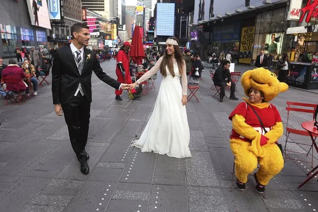 Berta and Jose Fernandez from Spain walk though Times Square as they pose for wedding photos in the Manhattan borough of New York November 11, 2015. (Photo by Carlo Allegri/Reuters)