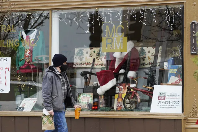 Christmas cards and costumes are displayed in the window at Mid Central Printing & Mailing store in Wilmette, Ill., Friday, December 18, 2020. Isolated by the coronavirus pandemic, Americans are sending more Christmas and holiday cards to stay in touch this year. (Photo by Nam Y. Huh/AP Photo)