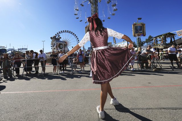 An Oktoberfest visitor swings her dirndl, at the start of Oktoberfest, on Munich's Theresienwiese, in Germany, Saturday, September 20, 2025. (Photo by Karl-Josef Hildenbrand/dpa via AP Photo)
