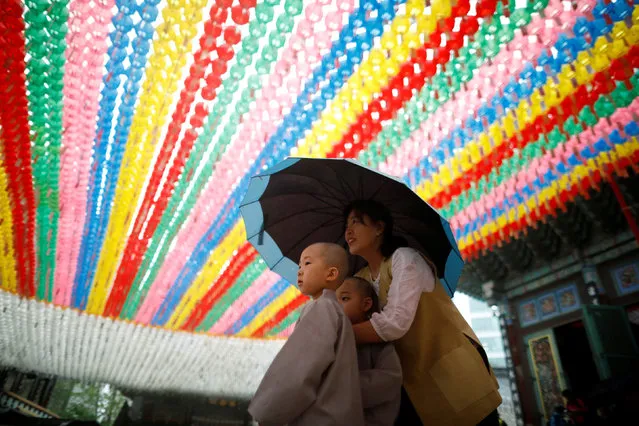 Novice monks walk underneath lotus lanterns bearing prayer petitions as they leave after an event to celebrate the upcoming Vesak Day, the birthday of Buddha, at Jogye temple in Seoul, South Korea, May 2, 2018. (Photo by Kim Hong-Ji/Reuters)