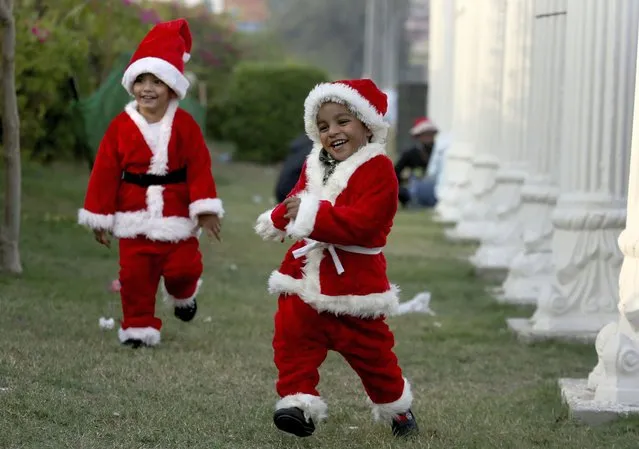 Christian children wearing Santa Claus suits run toward their parents as they prepare to participate in a Christmas celebration rally, in Karachi, Pakistan, Sunday, December 20, 2020. (Photo by Fareed Khan/AP Photo)