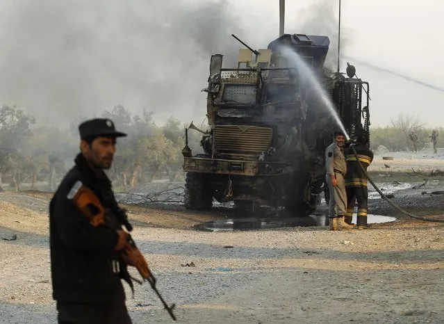 Afghan firefighters spray water on a U.S. armoured vehicle after a suicide attack on the outskirts of Jalalabad, January 5, 2015. A suicide attacker targeted a U.S. convoy on the outskirts of Jalalabad on Monday but so far no causalities have been reported yet, provincial spokesman Ahmadzia Abdulzai said. (Photo by Reuters/Parwiz)