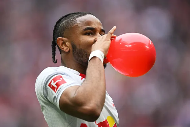 Christopher Nkunku of RB Leipzig celebrates with a balloon after scoring their sides first goal during the Bundesliga match between RB Leipzig and TSG Hoffenheim at Red Bull Arena on April 29, 2023 in Leipzig, Germany. (Photo by Stuart Franklin/Getty Images)