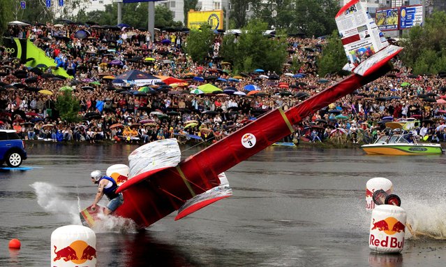 A flying team falls into water after taking off during the Red Bull Flugtag 2013 competition in Kiev, Ukraine, on June 2, 2013. (Photo by Sergei Chuzavkov/Associated Press)