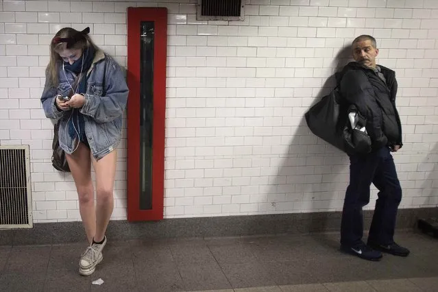 A man looks at a participant taking part in the “No Pants Subway Ride” in the Manhattan borough of New York January 11, 2015. (Photo by Carlo Allegri/Reuters)