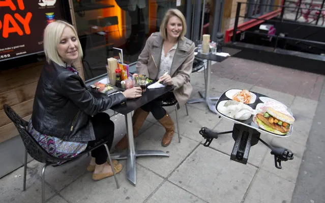 A flying sushi service tray known as the “itray”, created using miniature remote-controlled helicopter rotor blades, is demonstrated by staff at a “Yo! Sushi” restaurant in London June 10, 2013. (Photo by Neil Hall/Reuters)