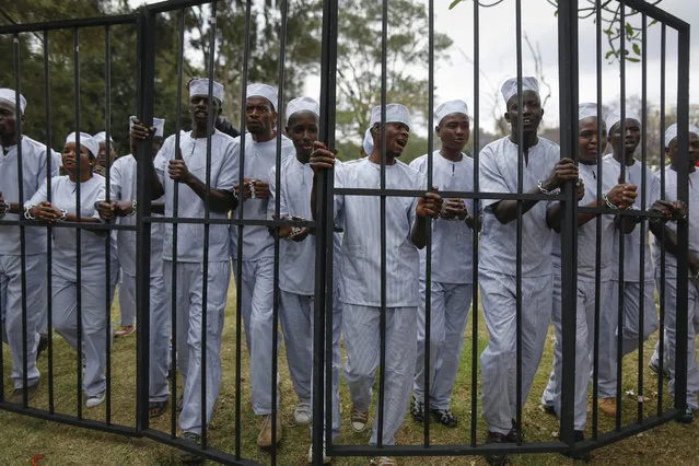 Protesters wearing mock prison uniforms walk with a mock prison pen to demand corrupt government officials to be jailed during a demonstration to demand President Uhuru Kenyatta to act on corruption or resign, in downtown Nairobi, Kenya, 03 November 2016. Kenyan police fired tear gas at protesters, led by a prominent civil rights activist Boniface Mwangi, and at journalists who were covering them. Hundreds of protesters gathered in response to reports by local media that some 50 million US dollars were misappropriated at the health ministry. (Photo by Dai Kurokawa/EPA)