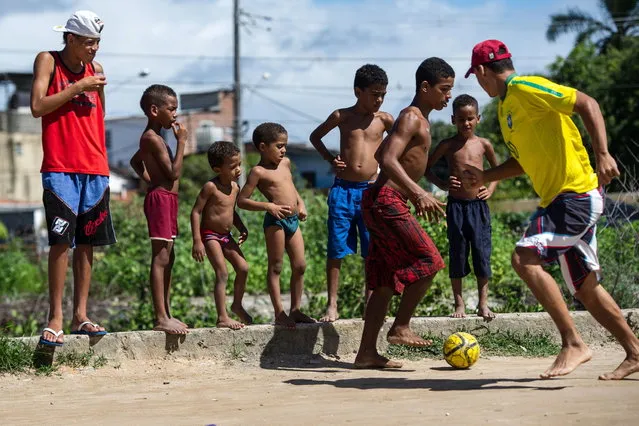 Boys play football in a shantytown of Olinda, about 18 km from Recife in northeastern Brazil, on June 18, 2013 as the FIFA Confederations Cup Brazil 2013 football tournament is being held in the country. The historic centre of Olinda is listed as an UNESCO World Heritage Site. (Photo by Yasuyoshi Chiba/AFP Photo)