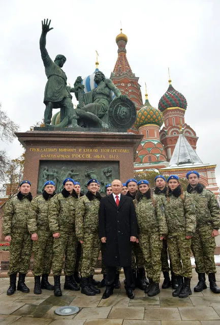 Russian President Vladimir Putin poses for a photo with members of a youth military patriotic club during a flower-laying ceremony at a memorial to Russian Duke Dmitry Pozharsky and merchant Kozma Minin who lead a victorious revolt against Polish rulers in Moscow in 1612, on National Unity Day at Red Square in Moscow, Russia, November 4,  2016. (Photo by Alexei Druzhinin/Reuters/Sputnik/Kremlin)