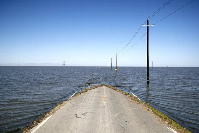 Water engulfs a road in Helm Corner, California, USA, 18 May 2023. The long dry Tulare Lake, once the largest lake west of the Mississippi before the 1920s, is filling up again with water after a winter of heavy rain and flooding. Flooding in the region is only expected to get worse after record-deep snowpack in the Sierra Nevada starts to melt, bringing excess water to the surrounding areas. (Photo by Caroline Brehman/EPA)