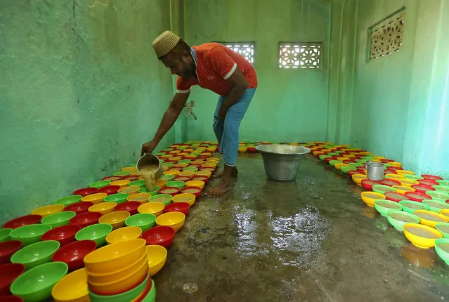 A Muslim man serves rice porridge for Iftar (breaking fast) meal inside a mosque during the holy fasting month of Ramadan in Chennai, India, May 29, 2018. (Photo by P. Ravikumar/Reuters)