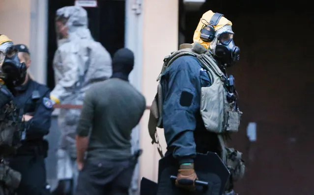 In this Tuesday June 12, 2018 photo, German police officers in protective gear leave an apartment building during an operation in Cologne, Germany. German police are searching the apartment of a 29-year-old Tunisian man who is accused of keeping toxic substances in his home. (Photo by David Young/DPA via AP Photo)
