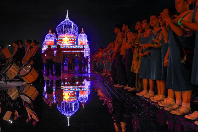 Malaysian students lines up in front of an illuminated decoration symbolising Russia during a light show in Kuala Lumpur, Malaysia, Tuesday, December 8, 2015. The light show features the different countries of ASEAN. (Photo by Joshua Paul/AP Photo)