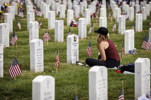 Krista Meinert sits with her son, US Marine Corps Lance Corporal Jacob Meinert who was killed in Afghanistan, at Arlington National Cemetery on Memorial Day, May 29, 2023 in Arlington, Virginia. The U.S. celebrates Memorial Day each year to honor those who have died while serving in the armed forces. (Photo by Samuel Corum/Getty Images)