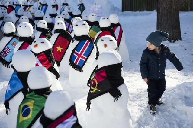 A little boy walks next to snowmen representing the countries around the world during an exhibition from the NGO “Action2015”, on the sideline of the 45th Annual Meeting of the World Economic Forum (WEF), in Davos, Switzerland, 21 January 2015. The overarching theme of the Meeting, which takes place from 21 to 24 January, is “The New Global Context”.  (Photo by Jean-Christophe Bott/EPA)