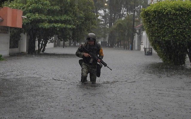 A soldier walks through flooded waters due to heavy rains in Boca del Rio, Veracruz, Mexico on October 21, 2024. (Photo by Victoria Razo/AFP Photo)