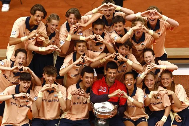 Serbia's Novak Djokovic celebrates with the trophy and ball kids after winning the French Open on June 11, 2023. (Photo by Clodagh Kilcoyne/Reuters)