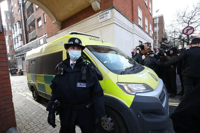 Police officers and security guards clear a pathway for an ambulance on Monday March 1, 2021, as it leaves the rear of the King Edward VII Hospital, London, where the Duke of Edinburgh was admitted on the evening of Tuesday February 16. (Photo by Yui Mok/PA Images via Getty Images)