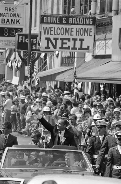 Neil Armstrong, the first man to walk on the moon and a hero to the world, waves to the hometown folks on September 6, 1969 during a big homecoming parade in his honor at Wapakoneta, Ohio. Armstrong's son, Mark, is beside him. (Photo by AP Photo)