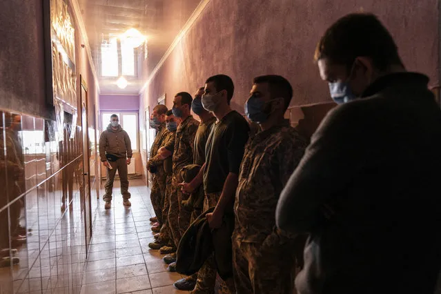 Ukrainian servicemen stand in line as they wait to receive a dose of the AstraZeneca COVID-19 vaccine marketed under the name CoviShield at a military base in Kramatorsk, Ukraine, Tuesday, March 2, 2021. (Photo by Evgeniy Maloletka/AP Photo)