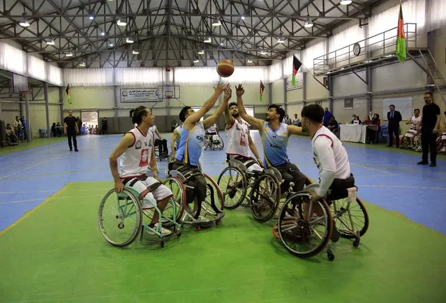 Disabled Afghan men take part in the final match of the national mens wheelchair basketball championship between Kabul and Maymana provinces, in Kabul, Afghanistan, Tuesday, March 16, 2021. The tournament is organized by the International Committee of the Red Cross. (Photo by Mariam Zuhaib/AP Photo)