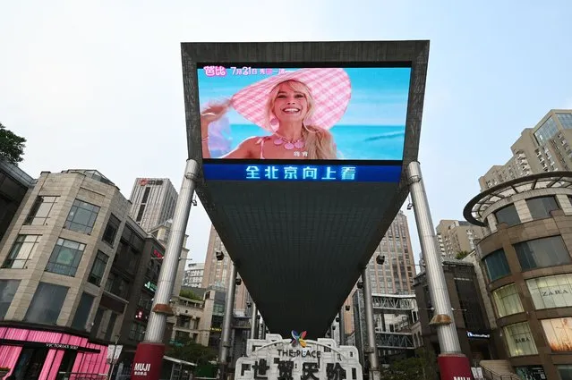 A promotion for the movie “Barbie” is pictured on a giant screen outside a shopping mall in Beijing on July 20, 2023. (Photo by Greg Baker/AFP Photo)