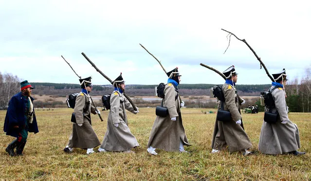 People dressed in the historic uniforms of the Imperial Russian army take part in a re-enactment of the 1812 Battle of Berezina, to mark the 204th anniversary of the battle, near the village of Bryli, Belarus, November 27, 2016. (Photo by Vasily Fedosenko/Reuters)