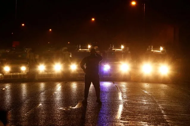 A man stands in front of a line of police vehicles at Springfield Road as protests continue in Belfast, Northern Ireland, April 7, 2021. (Photo by Jason Cairnduff/Reuters)