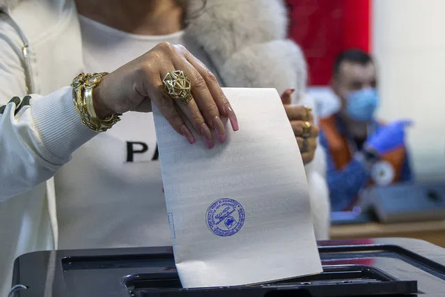 A woman casts her ballot during parliamentary elections in capital Tirana, Albania, Sunday, April 25, 2021. Albanians are voting in parliamentary elections amid the virus pandemic and a bitter political rivalry between the two largest political parties. (Photo by Visar Kryeziu/AP Photo)