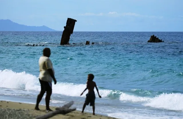Local people play near debris of the Japanese Imperial Navy transport vessel Kinugawa Maru at Tassafaronga beach on September 3, 2016 in Guadalcanal Island, Solomon Islands. (Photo by The Asahi Shimbun via Getty Images)
