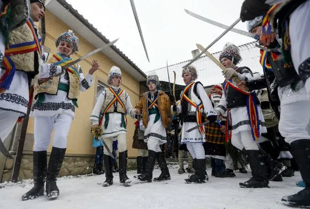 Participants, dressed in traditional costumes, perform while visiting local houses during the celebrations for Malanka holiday in the village of Krasnoilsk in Chernivtsi region, Ukraine, January 14, 2016. (Photo by Valentyn Ogirenko/Reuters)