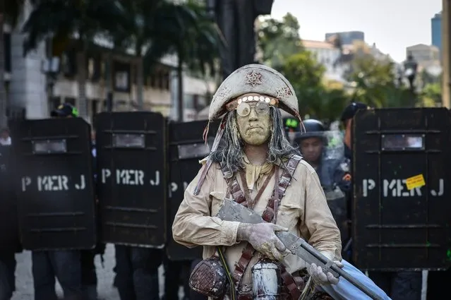 A street performer is seen during a teacher protest against corruption in the office of Rio Governor Sergio Cabral, in Rio de Janeiro, Brazil on October 1, 2013. Brazil has seen large street protests since last June, directed towards the country's ruling elite in demand of better public services and an end to political corruption. (Photo by Yasuyoshi Chiba/AFP Photo)