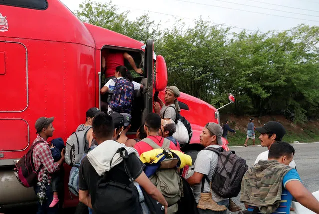 Central American migrants gather to hitchhike on a trailer truck to continue their journey to the Mexican border, in Zacapa, Guatemala on October 24, 2018. (Photo by Luis Echeverria/Reuters)