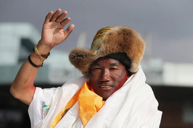 Nepalese veteran Sherpa guide, Kami Rita, 48, waves as he arrives in Kathmandu, Nepal, Sunday, May 20, 2018. Rita, scaled Mount Everest on Wednesday morning May 16 for the 22nd time, setting the record for most climbs of the world's highest mountain, officials said. (Photo by Niranjan Shrestha/AP Photo)