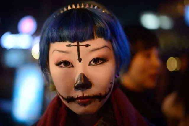 A woman with make-up poses while revellers celebrate Halloween in Beijing on October 31, 2013. (Photo by Ed Jones/AFP Photo)